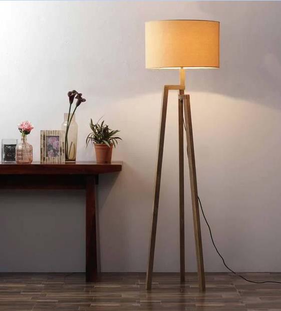 Đèn cây chân gỗ đơn giản đặt cạnh góc bàn trang trí cũng làm bừng sáng không gian